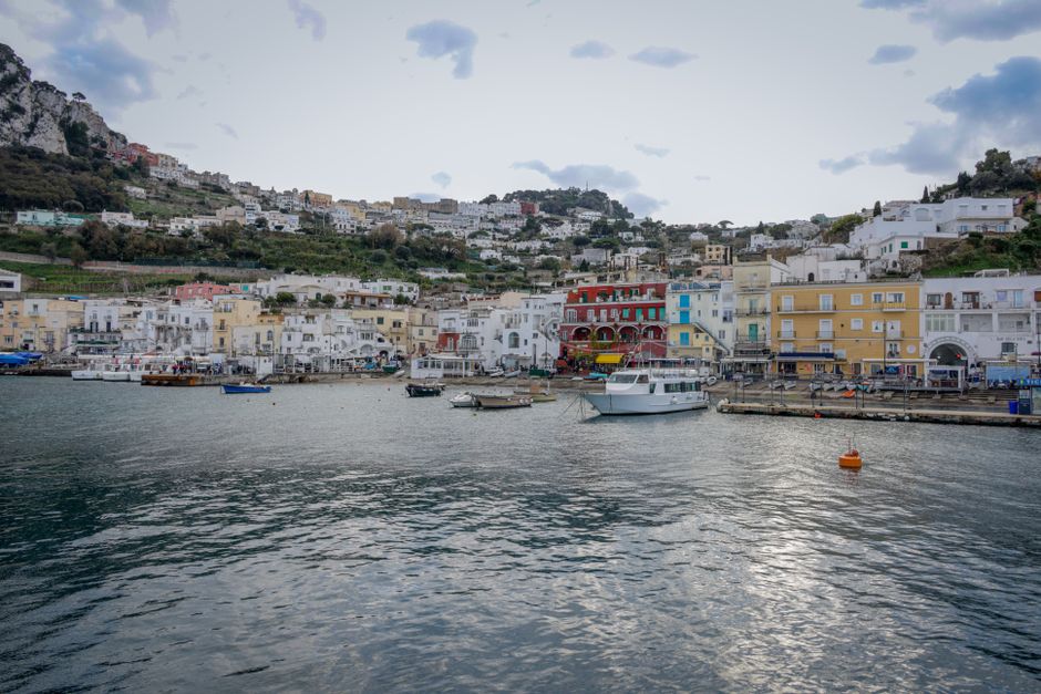 Beautiful harbor view of colorful buildings and boats in Capri, Italy.