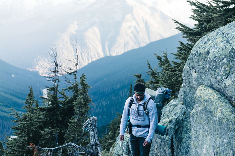 A determined hiker traverses a rugged mountain landscape in Canada.