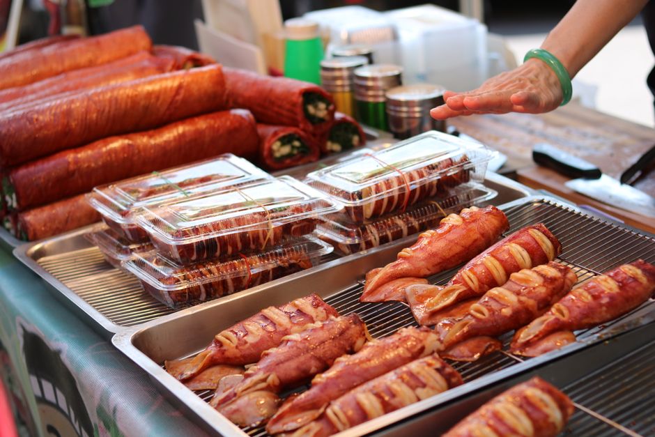Freshly grilled skewered meat displayed at a vibrant market stall, ready to enjoy.