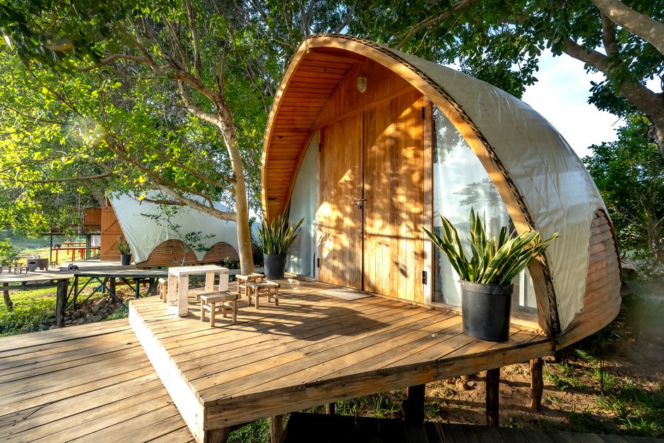 Charming wooden cabin with deck, nestled in forest, perfect nature retreat.