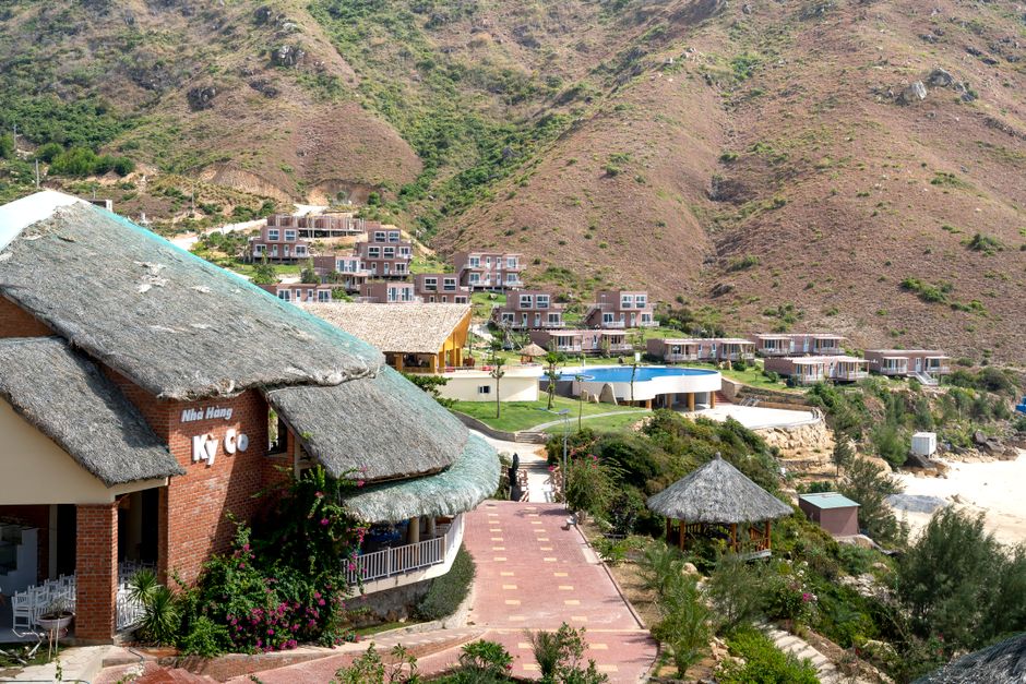 Remote village with modern cottages and creative houses under straw roofs located on hilly grassy terrain on sunny weather
