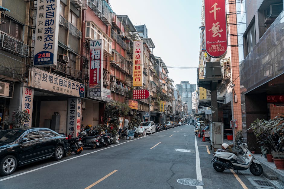 Vibrant city street lined with Asian signage and vehicles, capturing urban life.