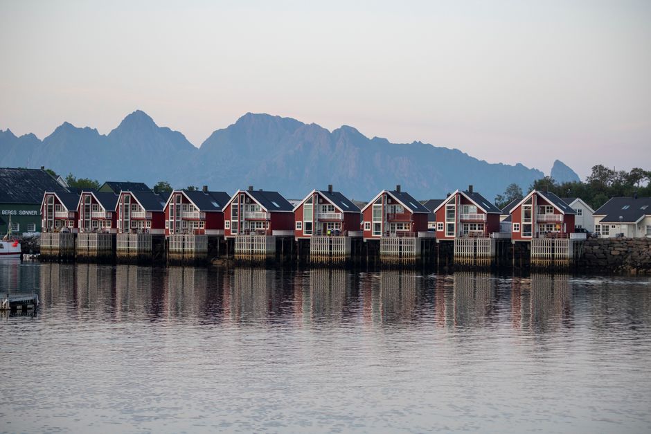 Charming waterfront houses with mountain backdrop in Nordland, Norway during dawn.