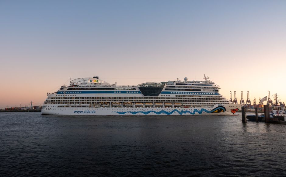 AIDA cruise ship docked in Hamburg harbor at sunset, showcasing the vibrant waterfront.