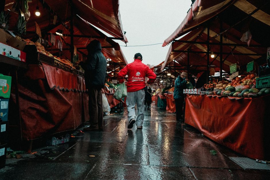 Wet market scene in Italy with people browsing fruit stands. Vibrant and lively.