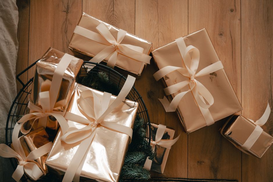 Top view of elegantly wrapped gift boxes with ribbons on wooden floor, perfect for holiday imagery.