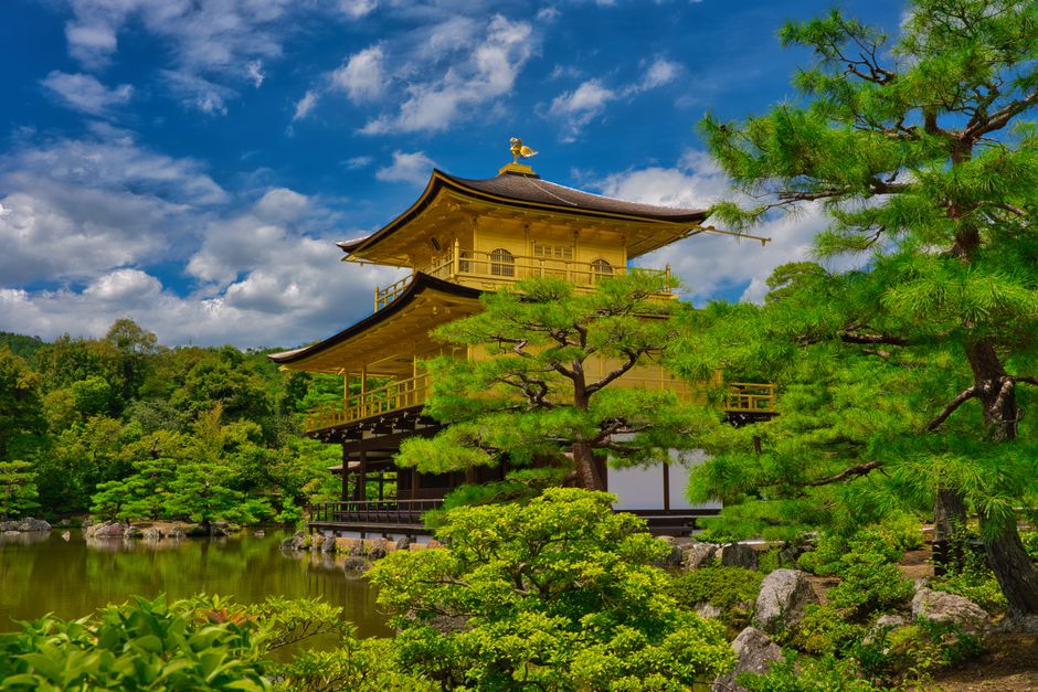 Photograph of the iconic golden Kinkaku-ji temple surrounded by lush greenery in Kyoto, Japan.