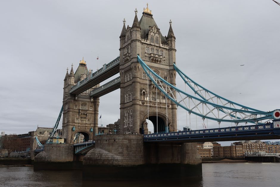 A view of the iconic Tower Bridge in London spanning the River Thames on a cloudy day.