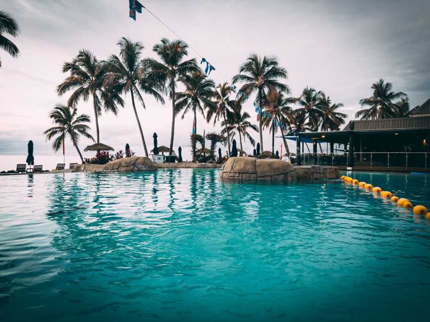 Stunning poolside with palm trees at a luxurious Fiji resort, perfect for a tropical escape.