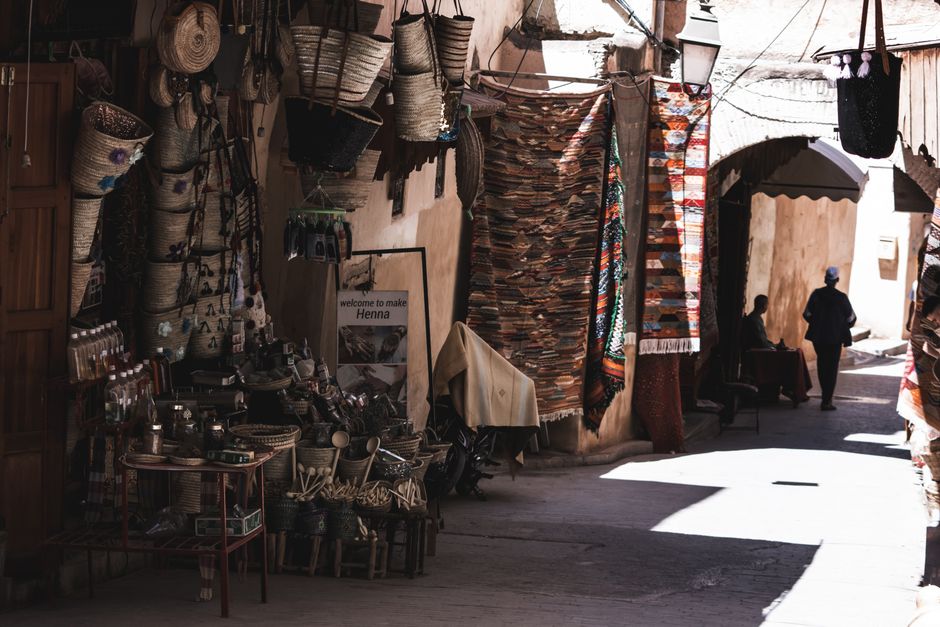 Explore the vibrant marketplace in a Moroccan medina with crafts and textiles.