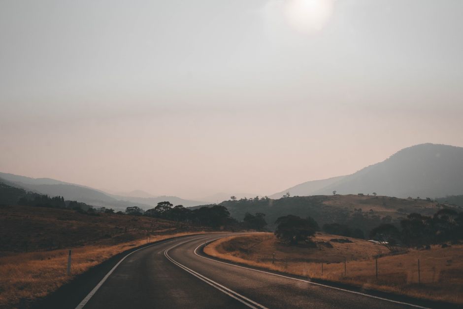 A picturesque highway winding through Thredbo's serene landscape during sunset in New South Wales, Australia.
