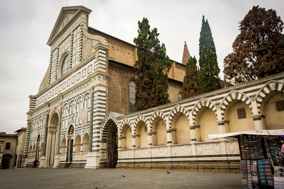 Low angle view of Santa Maria Novella's historic facade in Florence's gloomy weather.