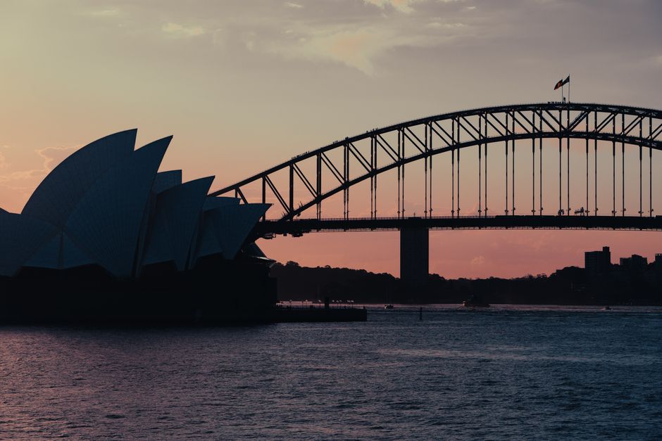 Captured at dusk, the Sydney Opera House and Harbour Bridge create a majestic skyline over Sydney Harbour.