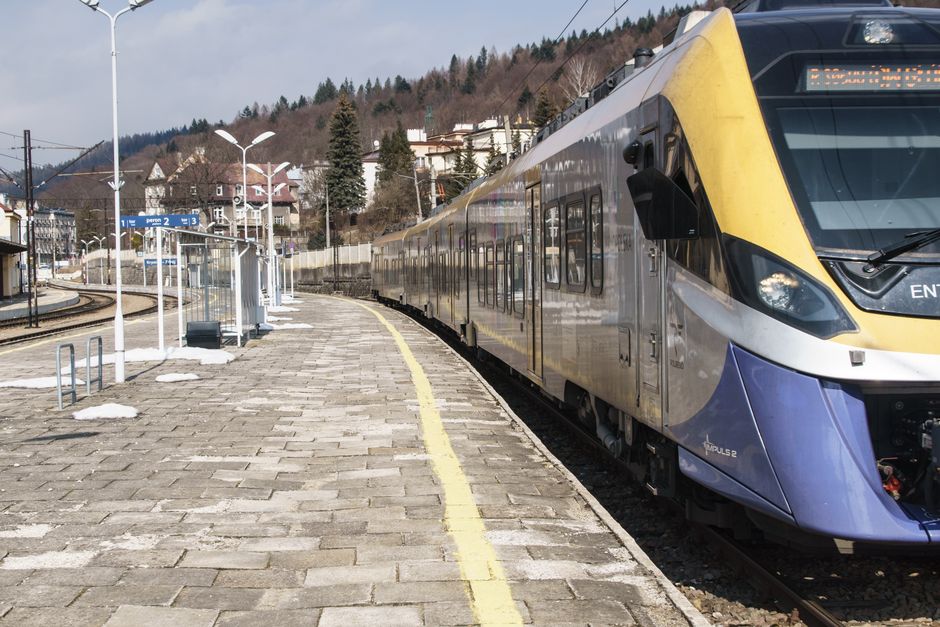 A sleek train waits at the platform of Krynica-Zdrój station in Poland, showcasing modern transportation.