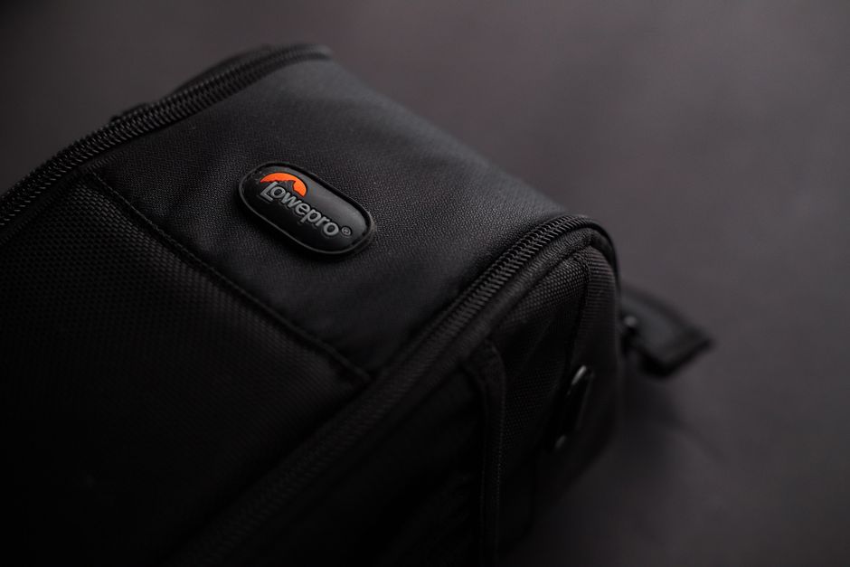 Close-up of a stylish black camera bag on a dark background, highlighting modern design.