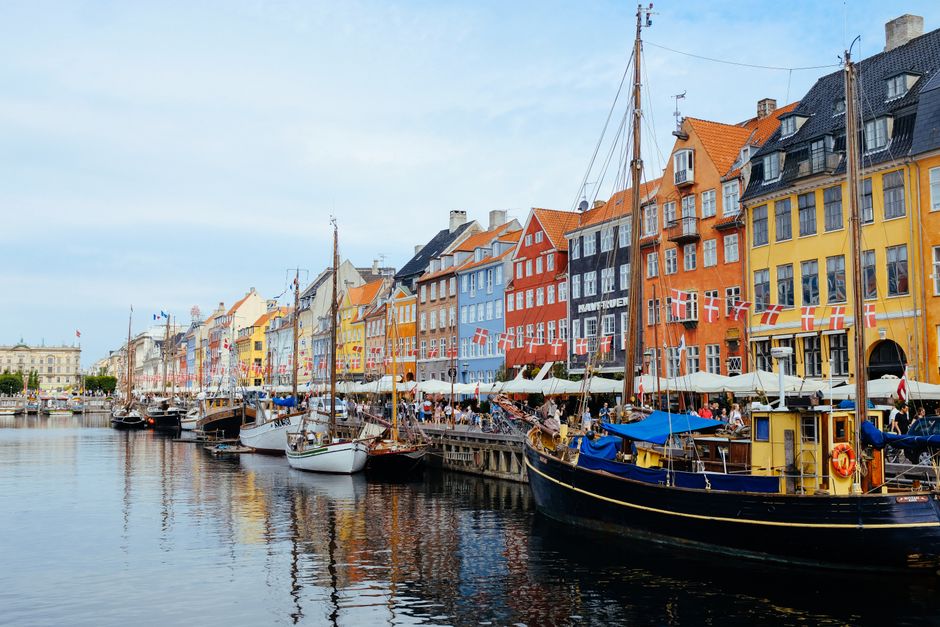 Colorful historic buildings and boats at Nyhavn harbor in Copenhagen, a picturesque tourist spot.