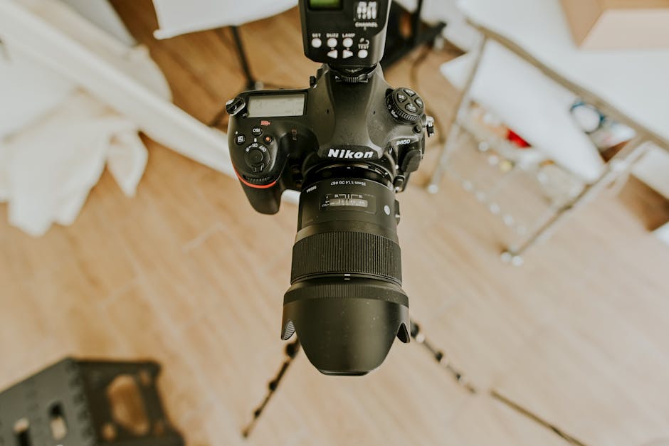 High-angle view of a DSLR setup with a long lens on a tripod indoors.